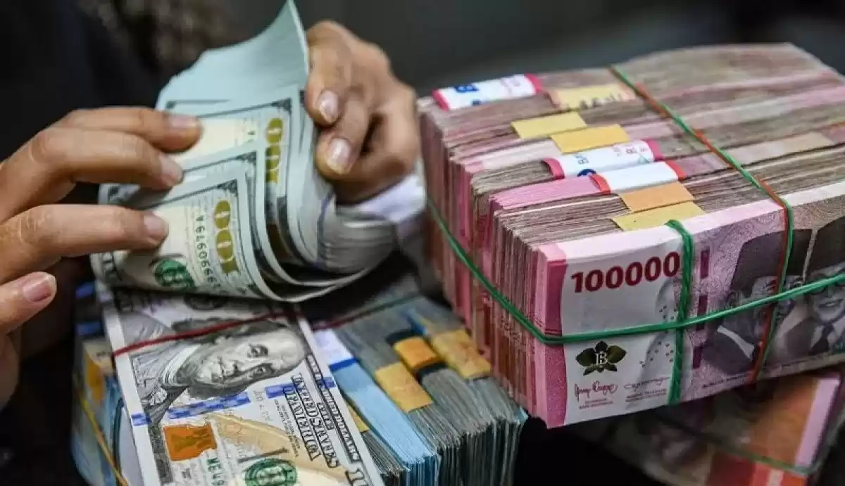 Petugas menghitung uang pecahan dolar AS dan rupiah di gerai penukaran mata uang asing VIP (Valuta Inti Prima) Money Changer, Jakarta (Foto: Antara)