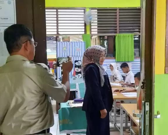Oknum pejabat Suku Dinas Pendidikan Jakarta Timur (Jaktim) berinisial Y sedang mendokumentasikan kegiatan seoarang Guru berinisial YL. Keduanya diduga memiliki hubungan spesial (Foto: Dok MI)