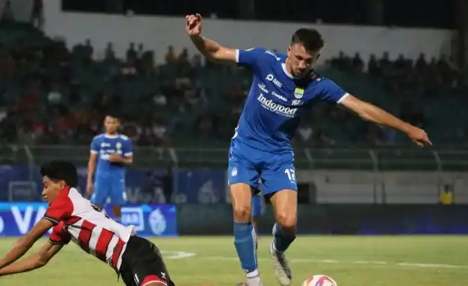 Pesepak bola Madura United Arsa Ramadan Ahmad terjatuh saat berebut bola dengan pesepak bola Persib Bandung Mateo (Foto: Antara)