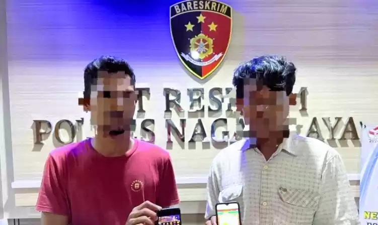 Kepolisian memperlihatkan dua pelaku judi slot daring saat diamankan di Mapolres Nagan Raya, Aceh, Rabu (1/5/2024). (Foto: Antara)