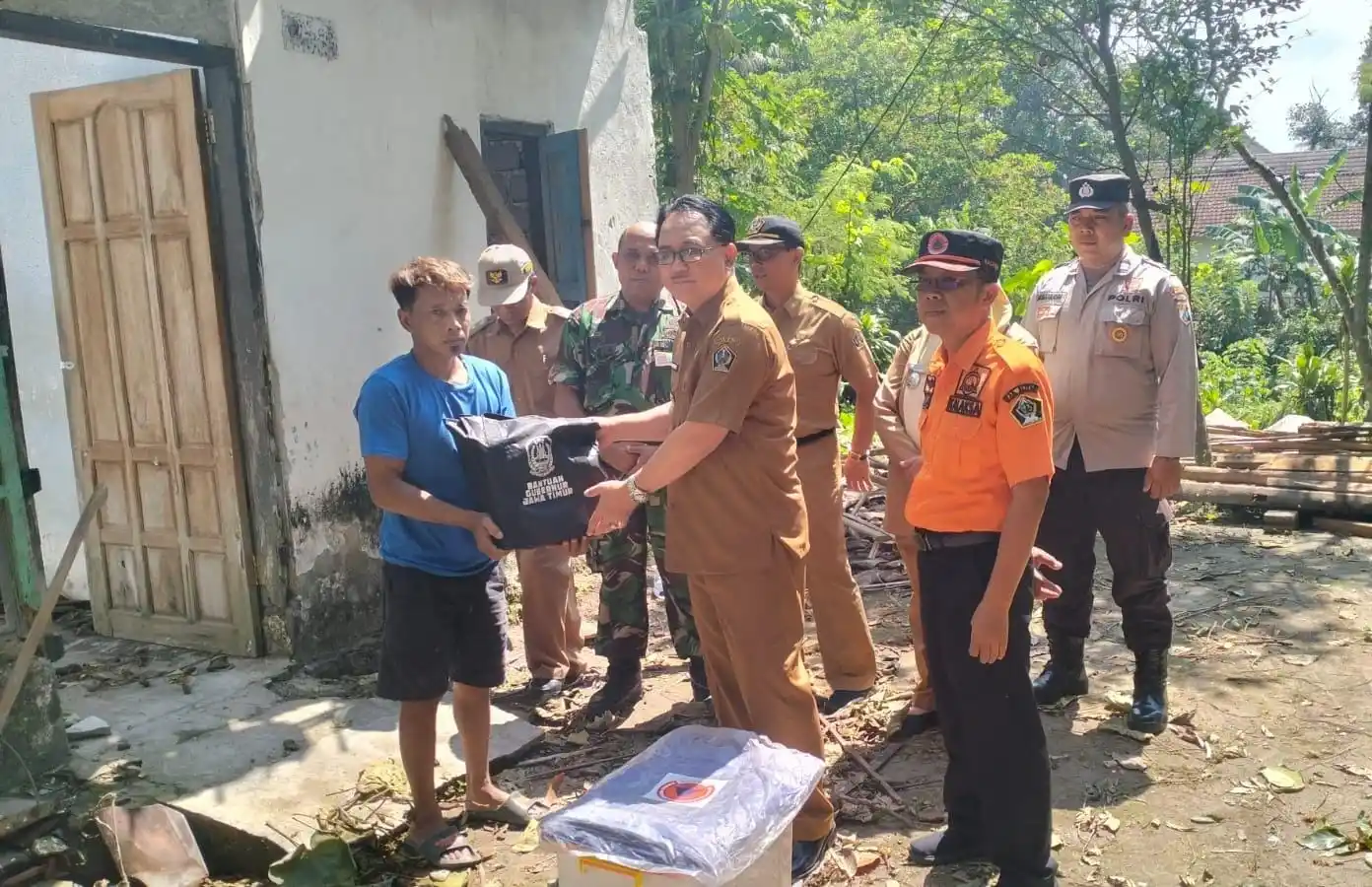 Pjs Bupati Blitar Jumadi bersama Kepala OPD terkait saat menyerahkan bantuan kepada warga terdampak di Desa Sukosewu, kecamatan Gandusari. (Foto: Dok MI/Joko Prasetyo)