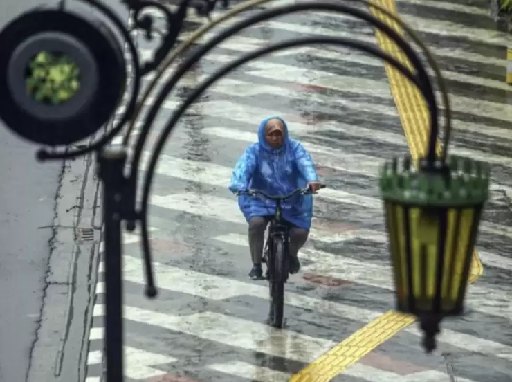 Pesepeda gunakan jas hujan. (Foto: ANTARA)