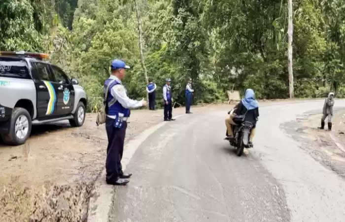 Petugas Dinas Perhubungan Lumajang melakukan penyekatan untuk penutupan jalur Piket Nol yang ditutup sementara akibat longsor pada Jumat (19/4/2024) pagi. (Foto: Antara)