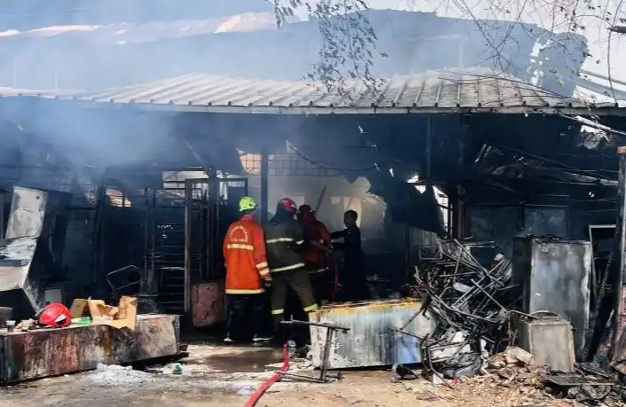 Petugas gabungan melakukan pendinginan di lokasi kebakaran toko reparasi alat kantor.(Foto: Antara)