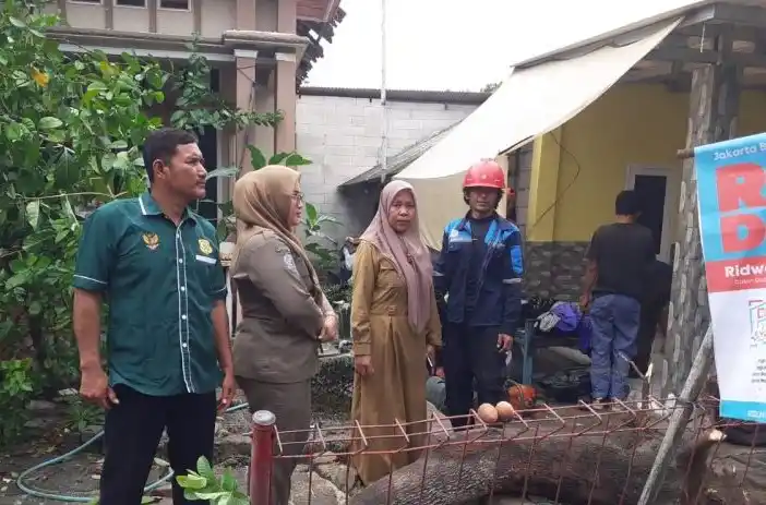 Petugas membersihkan puing bangunan yang terdampak angin puting beliung (Foto: Antara)