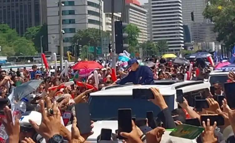 Presiden RI Prabowo Subianto berjabat tangan dengan warga yang tumpah ruah di Simpang Patung Kuda. (Foto: Antara)