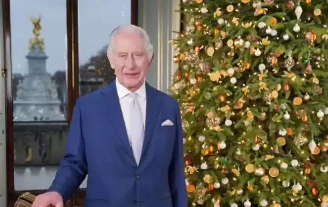 Raja Charles berdiri di samping pohon natal. (Foto: Antara)
                                    class=