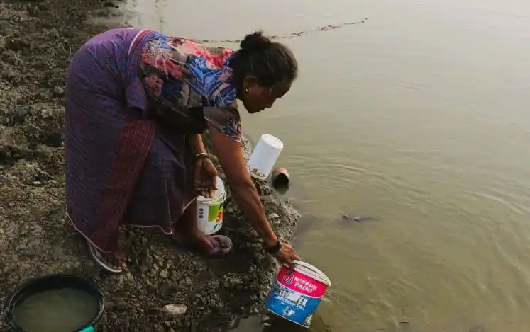 Seorang ibu mengambil air di embung yang keruh, Desa Kabuna, Atambua, Kabupaten Belu. (Foto: Antara)