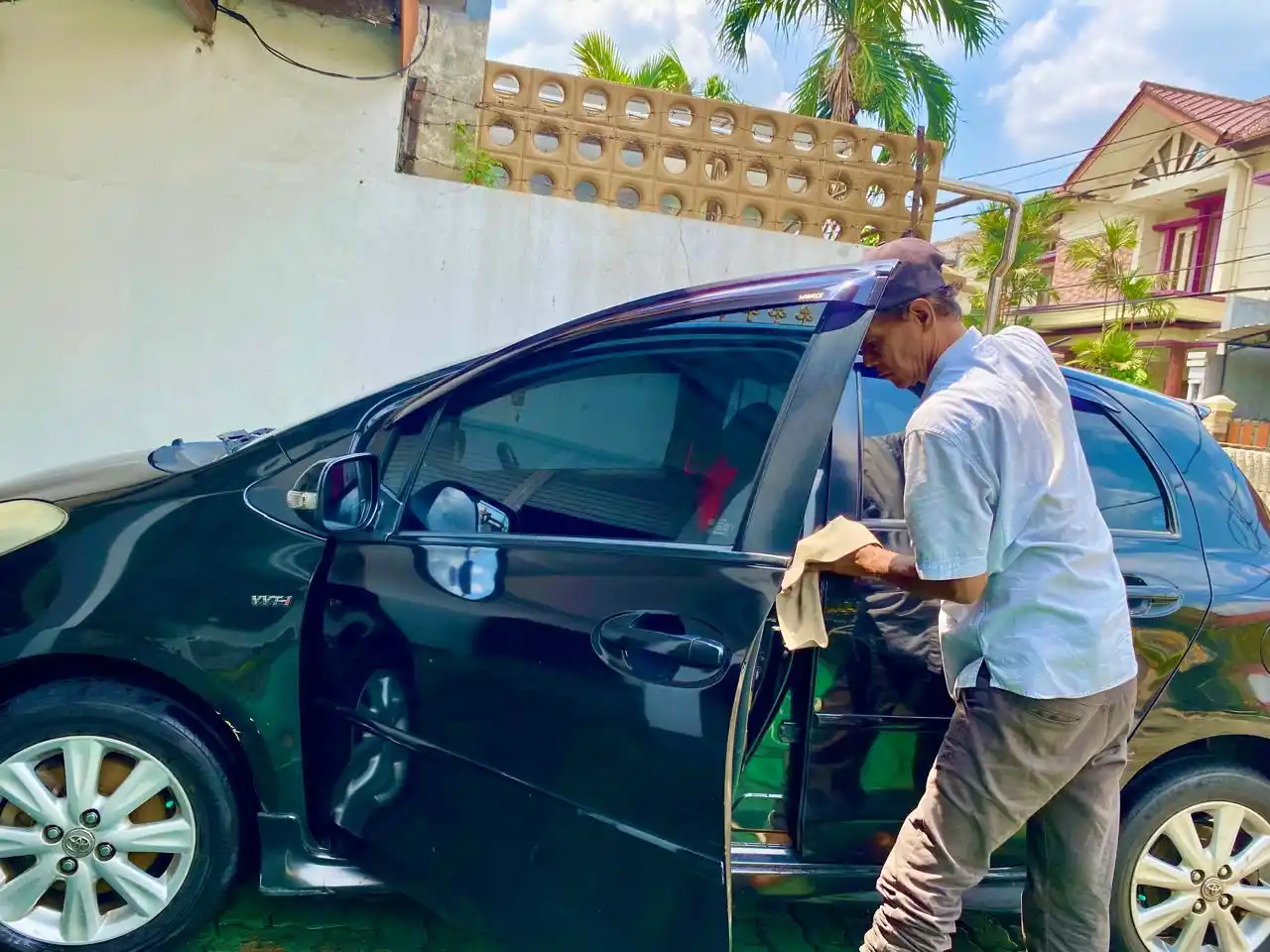 Seorang sedang mencuci mobil