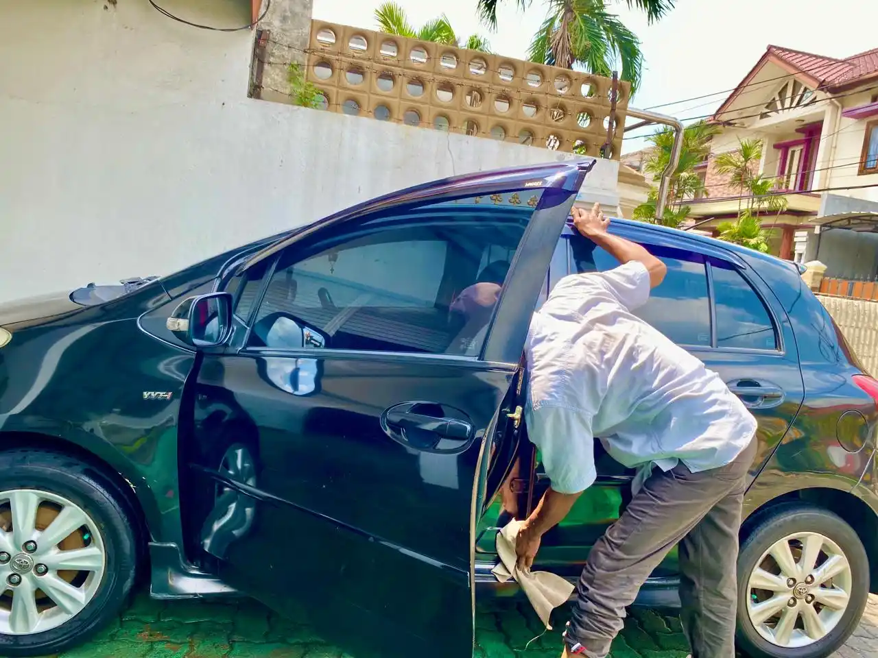 Seorang sedang mencuci mobil