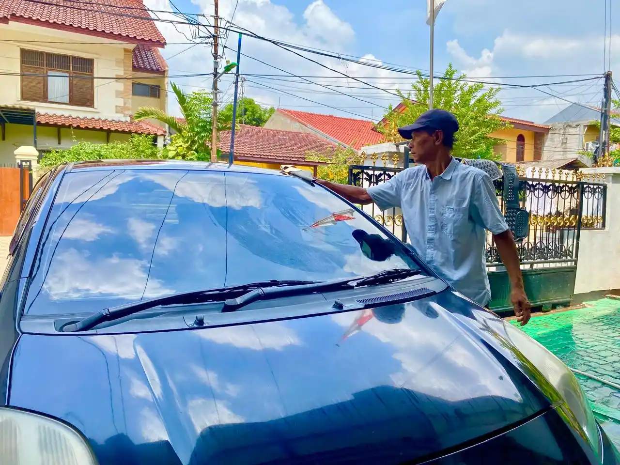 Seseorang sedang mencuci mobil pribadi di are rumahnya. (Foto: MI/ Nuramin)
