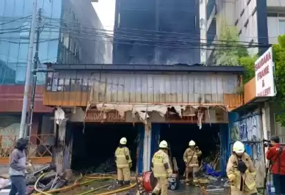 Petugas melakukan pendinginan di area ruko yang terbakar di Mampang Prapatan, Jakarta, Jumat (19/4/2024). (Foto: Antara)