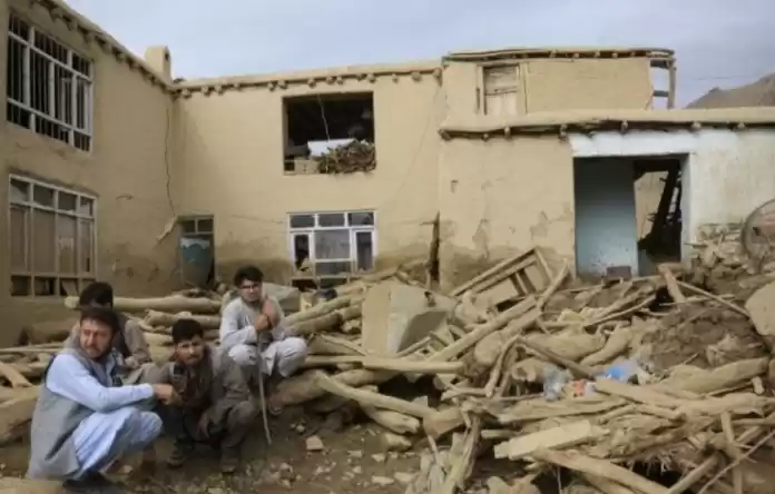 Sejumlah pria duduk merenungi rumah mereka yang tinggal tersisa puing-puing ketika banjir melanda. (Foto: Antara)