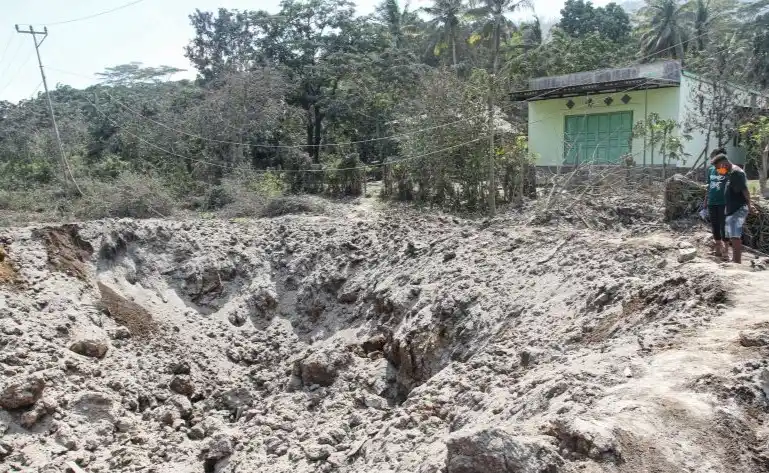 Warga melihat sisa material erupsi Gunung Lewotobi Laki-laki di Desa Klatanlo (Foto: Antara)