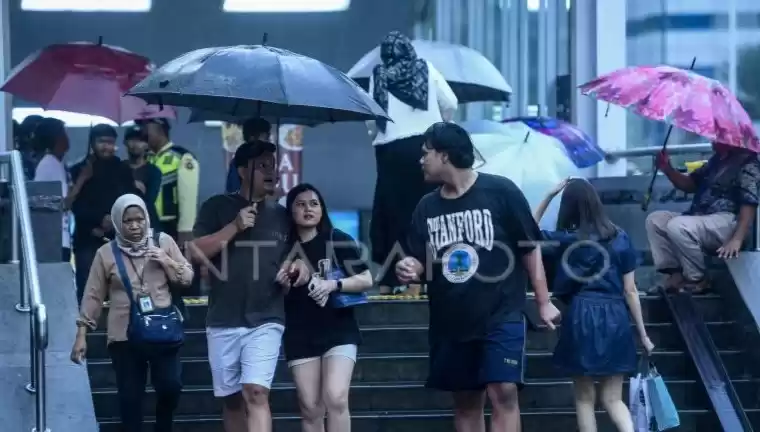 Warga menggunakan Payung di kawasan Stasiun MRT Sudirman. (Foto: Antara)