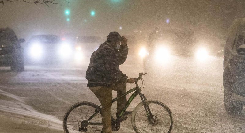 Seorang pesepeda menunggu untuk menyeberangi jalan di tengah badai musim dingin di Chicago, AS, 29 Desember 2020. (Foto: ANTARA)