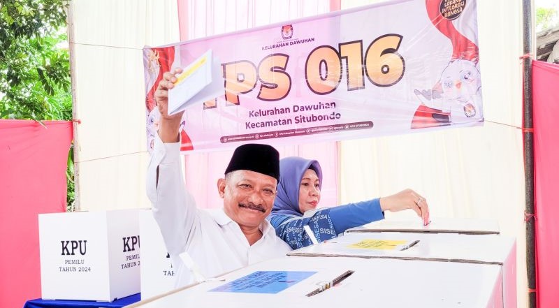 Bupati Situbondo Karna Suswandi bersama istri memasukkan surat suara ke kotak suara usai mencoblos di TPS 16 Kelurahan Dawuhan, Situbondo, Jawa Timur. Rabu (14/2) (Foto: ANTARA)